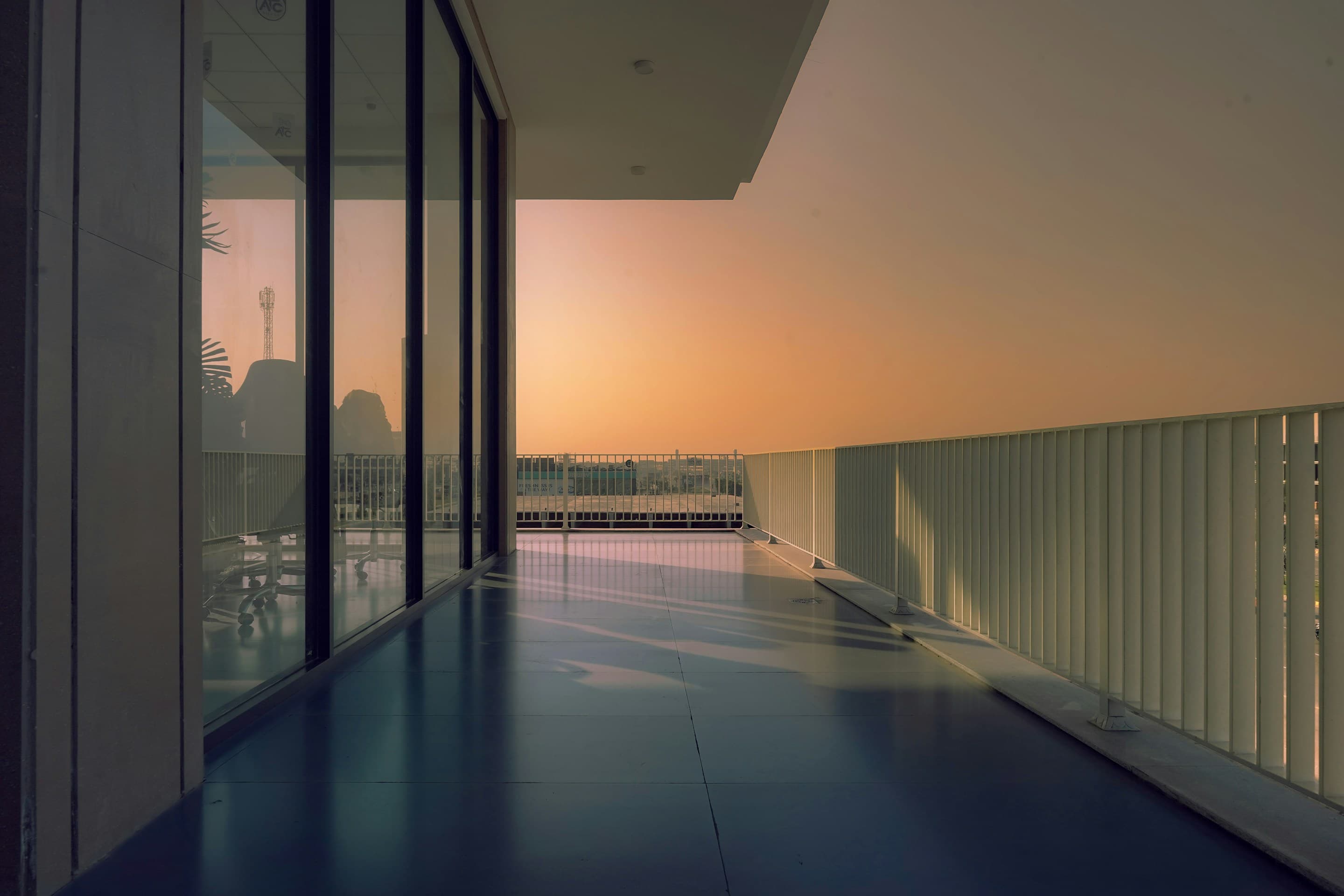 Modern luxury balcony overlooking a city at sunset